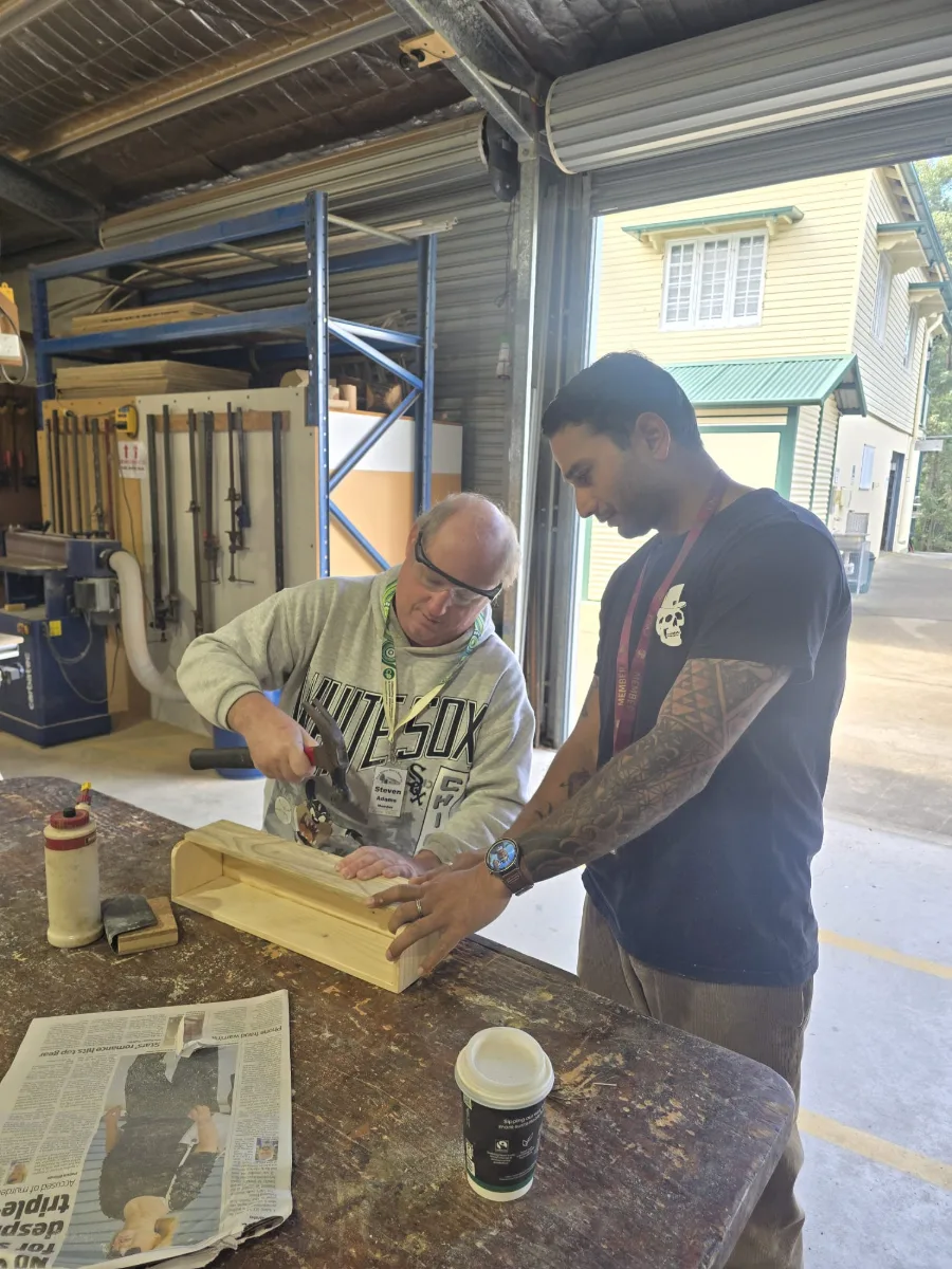 A support worker helping a participant with a woodwork project